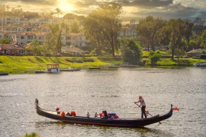Gondola on Lake San Marcos during sunset, with a gondolier paddling and guests enjoying a scenic cruise, reflecting the romantic dining experience offered by Black Swan Gondola.